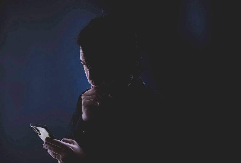 a groomer reading his phone in the dark